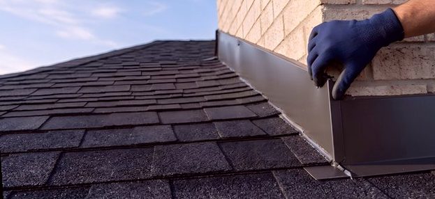 Hands setting new flashing metal against brick